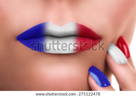 French kiss. Woman lips with lipstick makeup and nail polish in colors of French Flag. Make up manicure.