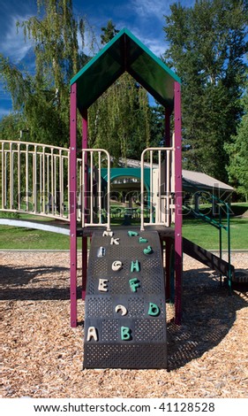A playground set containins slides, jungle gyms, brigdes and a climbing wall.