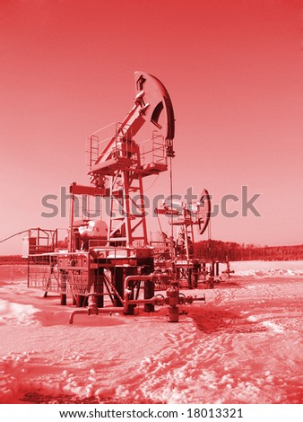 Oil pump jack in work. Oil industry in West Siberia. Siberian frost in sunny day. Colorize in red