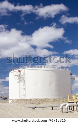 Oil and gas industry. Work of refinery petrochemical plant. Oil reservoir in desert. Blue sky and white clouds