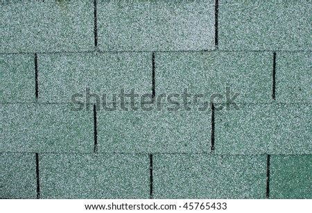 Closeup of a section of green asphalt roofing shingles