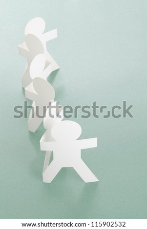 Row of Paper Chain People on Off White Background