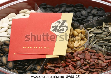 Chinese New Year red packets on snacks tray on white