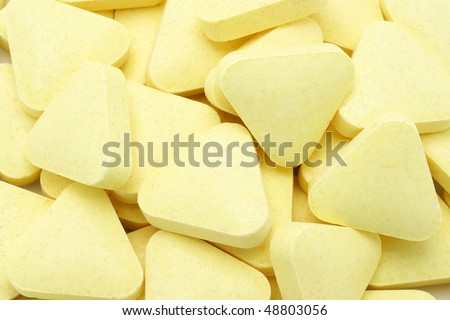Yellow color triangular shape multi vitamin tablets background