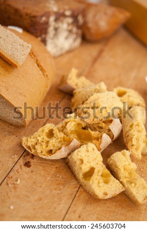Crumbled bread on a wooden desk.Small pieces of white bread. Whole loafs on a background. Food, home-made bread, nobody, macro perspective