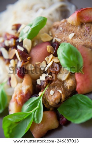 Fried chicken with garlic and honey in almonds. Served with rice pasta and apple sauce.  Decorated with raisins and basil leaves.