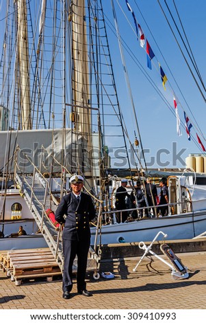 YSTAD, SWEDEN - AUGUST 6, 2015: Officer on duty by the gangplank during Nordic Cadet Meeting (NOCA), annual event arranged by naval warfare academies of Sweden, Norway, Denmark and Finland.