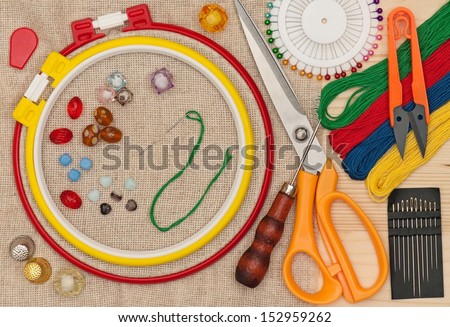 Various embroidery accessories with buttons and beads over outline