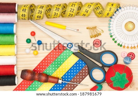 Bright sewing accessories over wooden surface close-up