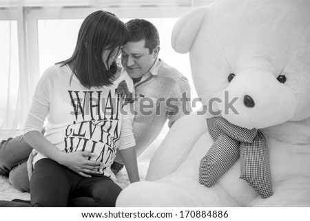 Happy expectant father who thinks it\'s a boy or a girl. Holding a doll and a ball