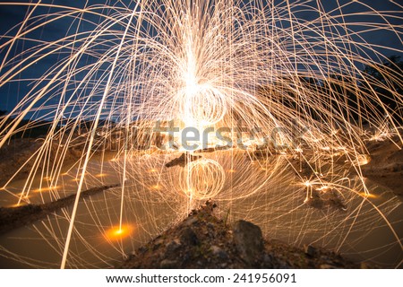 Spinning fire and light by use steel wool with the twilight time and blue hour