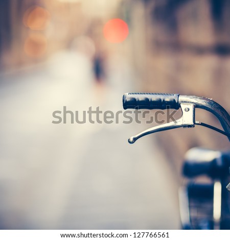 stock-photo-detail-of-a-vintage-bicycle-handlebar-resting-in-the-narrow-street-vintage-color-toned-image-127766561.jpg
