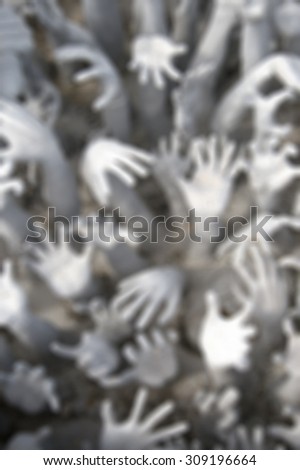 Many hands reaching up to grab.blurred backgrounds.