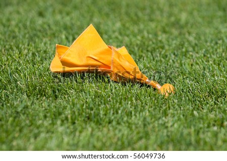 Yellow Penalty Flag on Green Grass During Play