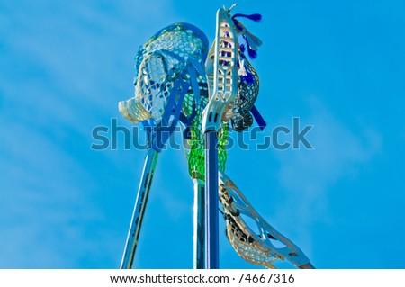 Four lacrosse sticks held in sky prior to the game starting
