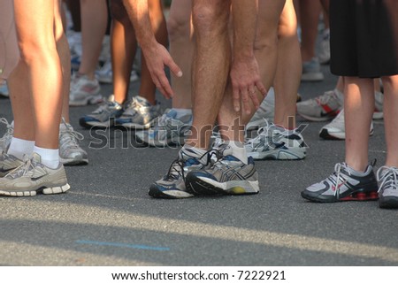 Runners\' Feet at Start of Race with Runner Stretching