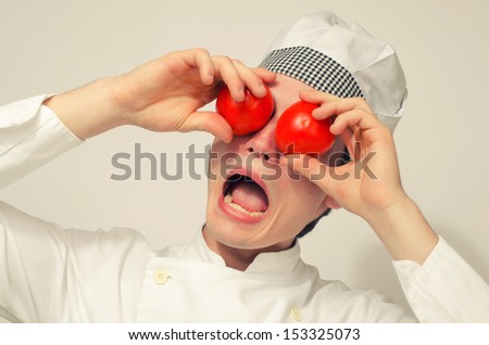 Funny chef playing with tomatoes and screaming