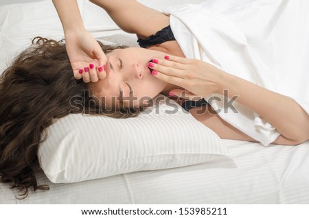 Woman sleeping. Beautiful girl in lingerie yawning and falling asleep on a soft pillow