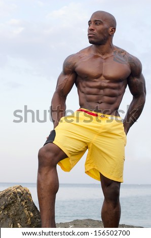 Black bodybuilder relaxing in the water after a hard workout during a summer vacation. Strong man with perfect abs, pecs shoulders,biceps, triceps