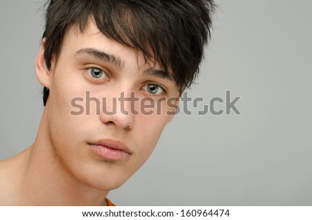 Portrait of an innocent handsome topless man posing fashion. Young guy with cool messy hairstyle.