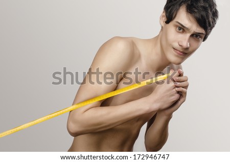 Skinny young man posing fashion with a centimeter, anorexic look. Slim body