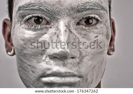 Man face painted with expression, man looking like a statue