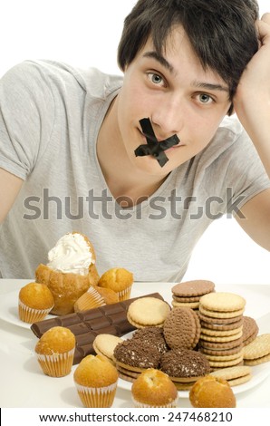 Man in love with sweets, candies,chocolate and sugar but trying to withhold. Forbidden sweets for a healthy longer life