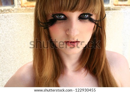 girl with a feather lashes in eyes, make up beauty portrait