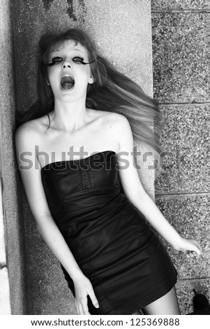girl with mouth open lying on the concrete benches