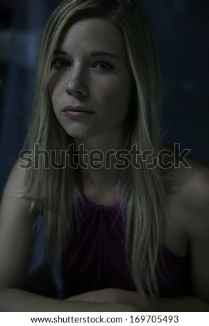 beautiful blond young woman in the dark, low key , dark background