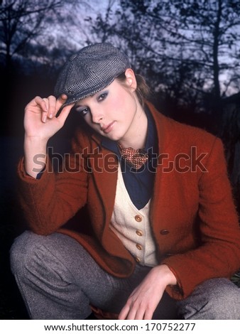 fashion model girl in a red jacket ran hat, beautiful blond girl in english style, beautiful girl dressed in the traditional English way, young woman with gray hat and red jacket in a winter day