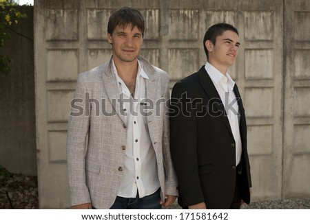 image of couple of two young businessman in town, Two businessmen having a meeting on terrace in the city, outdoors.