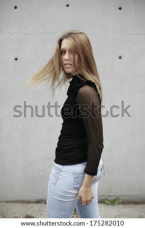 image of girl in white shirt and red scarf around the neck sitting on the fence looking  down