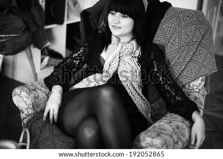 woman stretched out on the sofa in black leather jacket, black and white