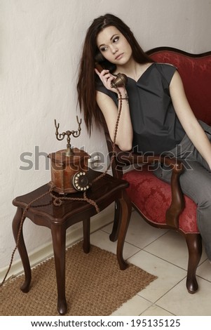 The call / Vintage style photo from a beautiful women, who is talking over old vintage phone , the vintage retro woman , Girl with golden wooden retro telephone