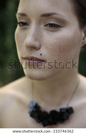 young woman with an interesting necklace made of black cubes , Portrait of a brunette with an interesting necklace made of black cubes