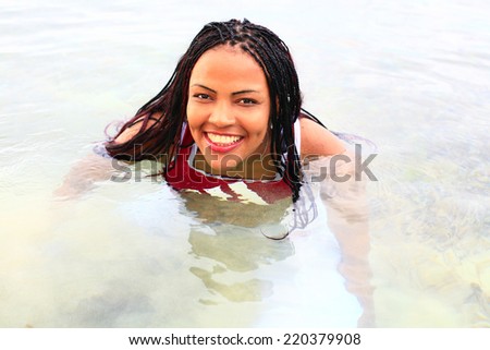 latina seducing in the sea, young woman swimming in water and smiling