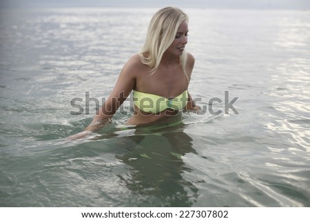 Blond angel on a blue background , blonde girl on the beach, beautiful blonde in water , Blond scandinavian woman by the ocean.Image of a beautiful Blond scandinavian woman by the sea horizon,