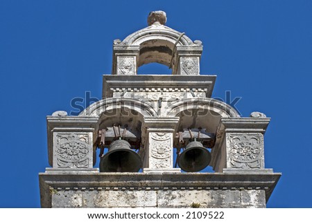 Church bell tower with two bells ringing.