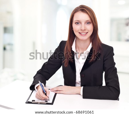 Positive bank official. Young woman sitting at the table.