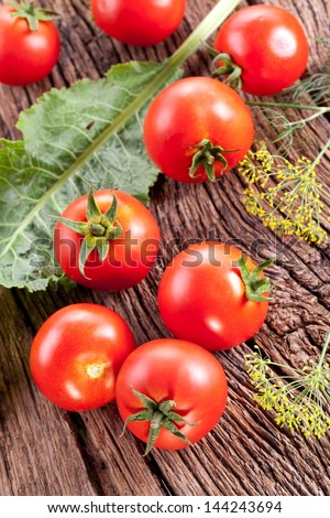 Tomatoes, cooked with herbs for the preservation on the old wooden table.