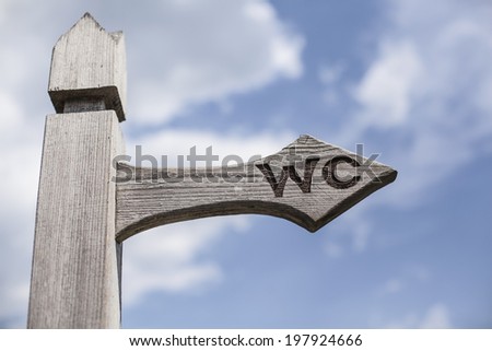 Old wooden signpost over blue sky background.