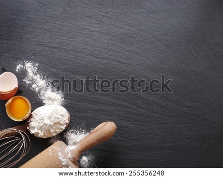 Dough preparation. Baking ingredients: egg and flour on black board.