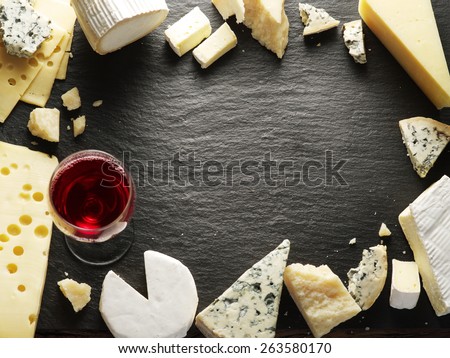 Different types of cheeses with wine glass. Top view.