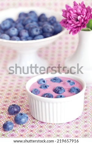 blueberry yogurt with a fresh berries in a cup on the table .