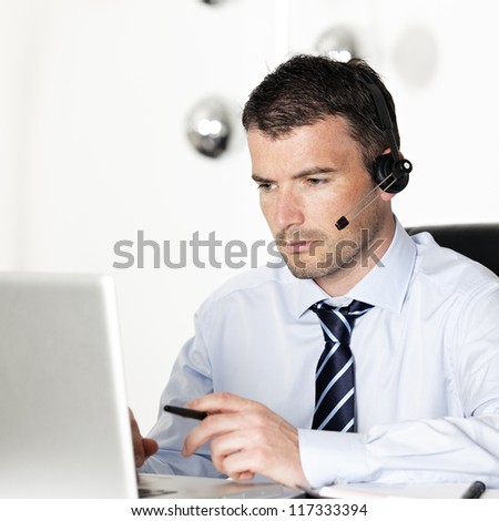 man in office with laptop and headset on his head