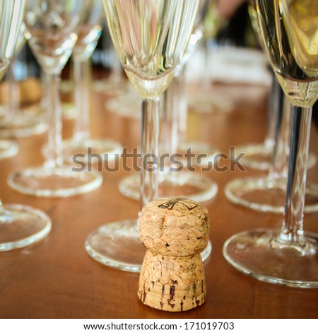 A cork stopper with the glasses of champagne
