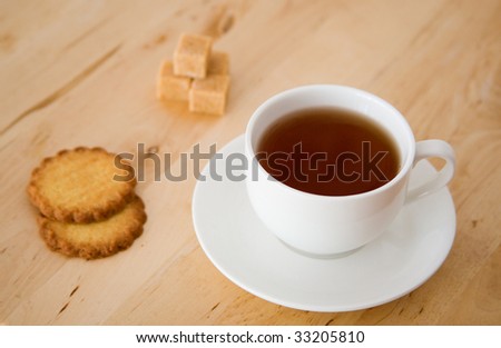 Cup of black tea, sugar and biscuits
