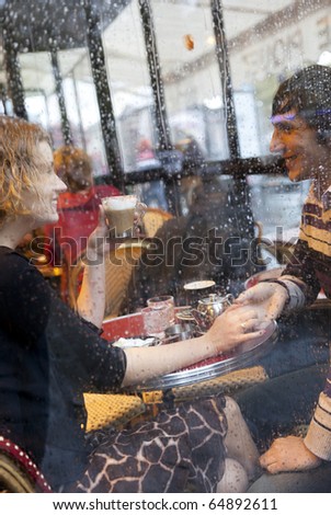 Happy couple in a Parisian cafe at rain