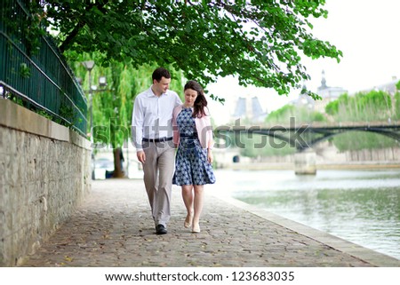 Romantic dating couple is walking by the water in Paris